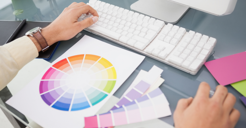 Colour Psychology: Colour wheel and swatches on a desk next to a computer.